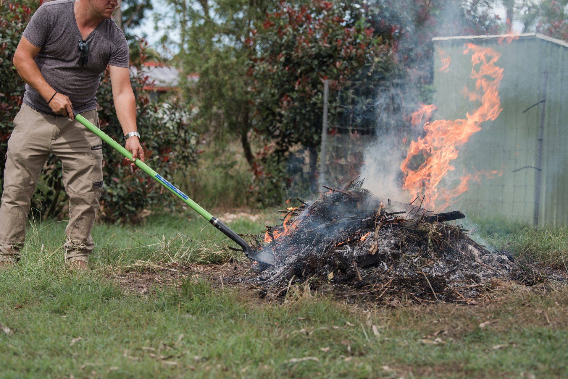 Man tending to fire controlled burn off of garden waste Man tending to fire controlled burn off of garden waste