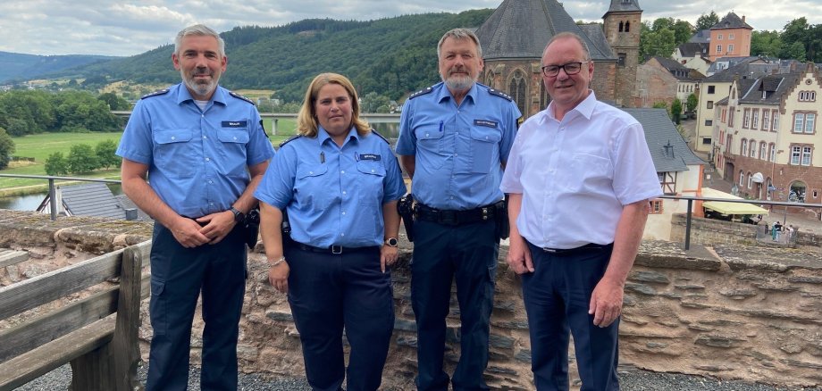 Portrait der Bezirksbeamten der Polizeiinspektion Saarburg und Bürgermeister Jürgen Dixius mit Blick auf Saar und Altstadt - Polizeihauptkommissar Bernhard Schiffmann, Polizeioberkommissarin Silke Brausch, Polizeihauptkommissar Volker Braun