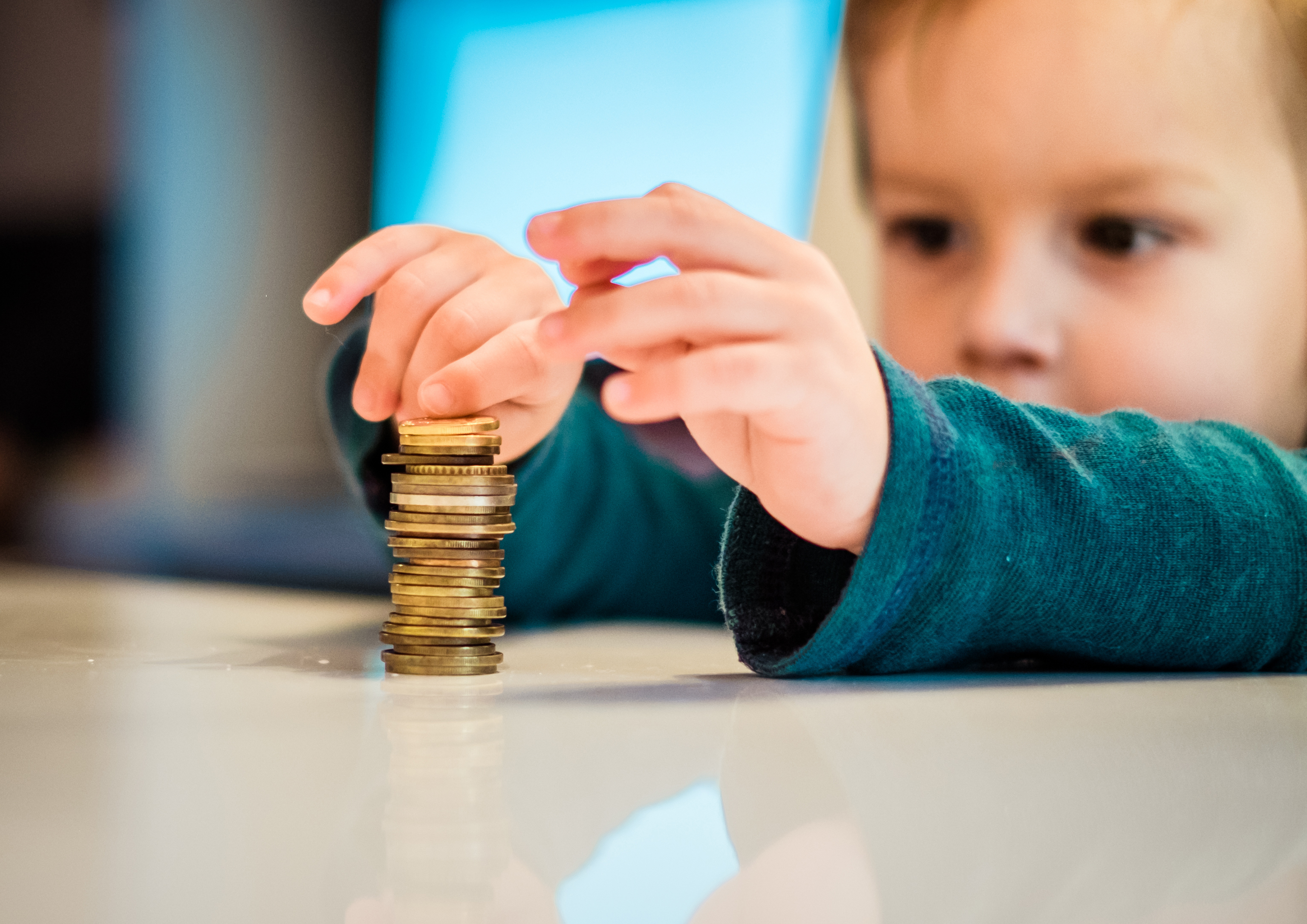 Close up boys hand making stucks of coins on the table