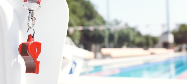 Coach whistle near swimming pool. Coral Coach whistle near swimming pool. Coral